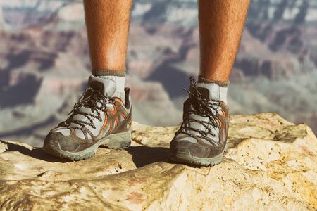 Mountain hike man hiker trekking travel walking with hiking shoes closeup of feet standing on rock.の写真素材