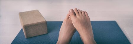 Barefoot yoga class woman shy feet lying on exercise mat at fitness studio room panoramic banner....