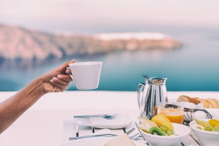 Drinking coffee cup at breakfast brunch table of cruise ship restaurant - luxury travel vacation getaway in Santorini - honeymoon destination.の写真素材
