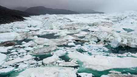 Iceberg in arctic landscape nature with icebergs and ice in Greenland icefjord. Aerial drone photo image of ice and iceberg. Ilulissat Icefjord with icebergs from glacier.の写真素材