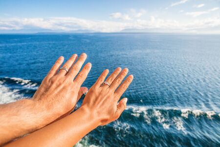 Cruise honeymoon travel vacation for newlyweds couple showing wedding rings on hand selfie at ocean view resort background. Luxury holidays.の写真素材