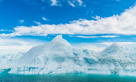 Global warming - Greenland Iceberg landscape of Ilulissat icefjord with giant icebergs. Icebergs from melting glacier. Arctic nature heavily affected by climate changeの写真素材