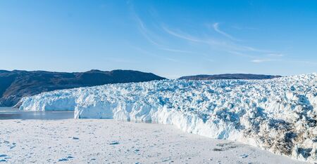 Greenland Glacier heavlly affected by Climate Change and Global Warming. Glacier front of Eqi glacier in West Greenland AKA Ilulissat and Jakobshavn Glacier. Produces many of Greenlands icebergs.の写真素材