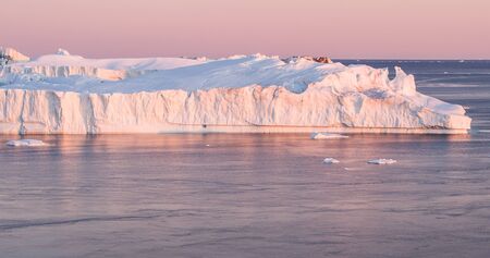 Climate Change and Global Warming - Icebergs from melting glacier in icefjord in Ilulissat,...