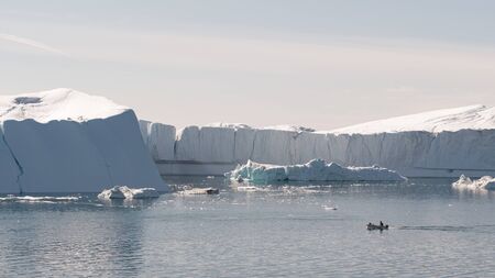 Ice and Icebergs from glacier - amazing arctic nature landscape aerial image of icefjord filled with icebergs from melting glacier Sermeq Kujalleq, Ilulissat, Greenland. Fishing boat.の写真素材