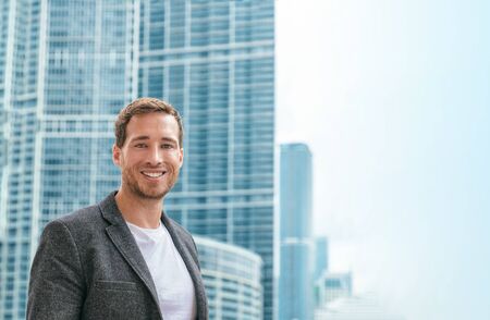 Confident young business man in smart casual blazer jacket portrait outdoor in city skyscrapers...