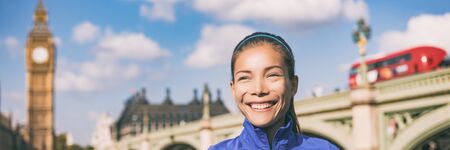 London woman portrait Asian girl smiling happy banner panoramic crop of Big Ben Clock tower and Westminster bridge with red double decker bus. Healthy fit city lifestyle., England, United Kingdom.の写真素材