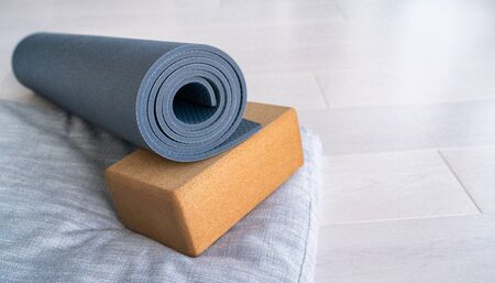 Yoga mat, cork block meditation pillow eco-friendly sustainable fitness products shopping. Natural organic material props for wellness studio on wooden floor background.の写真素材