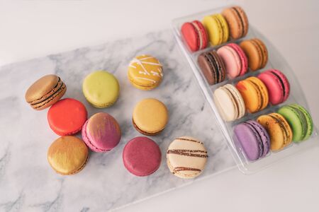 Top view of french macarons gift box macaroons wrapped in giftbox on marble board tabletop. Colorful selection of pastries.の写真素材