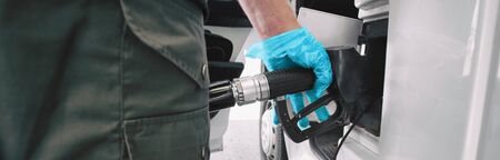 Gas pump Coronavirus outbreak protection gloves for touching handle while pumping gasoline at gas...
