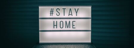 COVID-19 banner Coronavirus staying at home lightbox message sign with text, hashtag STAYHOME glowing in light to promote self isolation staying at home header background.の写真素材