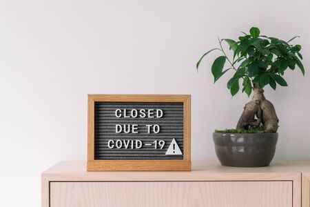 Closed business store due to COVID-19. Coronavirus lifestyle background with message sign at store...