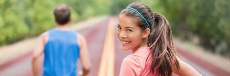 Running couple on road run in park banner panoramic header. Fit athletes runners man and woman...
