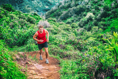 Trail running man athlete on marathon race. runner going up on mountain forest. Ultra running sport lifestyle.の写真素材
