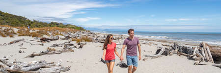 Panoramic banner of Couple walking on beach in New Zealand - people in Ship Creek on West Coast of New Zealand. Tourist couple sightseeing tramping on South Island of New Zealand.の写真素材