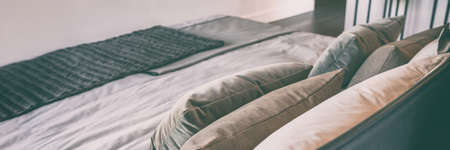 Bed in luxury hotel room bedroom with decoration pillows, banner panorama high end master suite home interior design.の写真素材