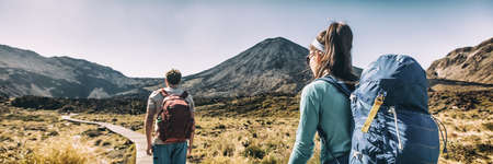 New Zealand Hiking Couple Backpackers Tramping At Tongariro National Park. Male and female hikers hiking by Mount Ngauruhoe. People living healthy active lifestyle outdoorsの写真素材