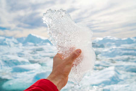 Global warming, climate change and Environmental protection concept with icebergs on Greenland. Hand...
