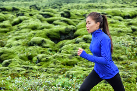 Woman runner training running outdoors. Fitness woman jogging outdoor. Morning running concept. Fit female on run.の写真素材