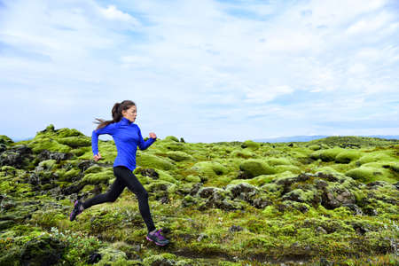 Woman running. Trail runner in cross country run. Female runner training jogging outdoors in...