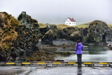 Iceland nature landscape on Arnarstapi Snaefellsnes. Travel photo of woman tourist looking at view...
