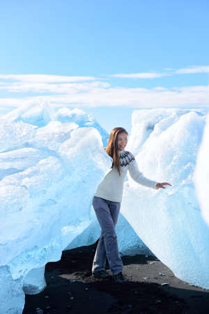Iceland tourist at Jokulsarlon Iceberg beach walking by icebergs on Ice beach. Breidamerkursandur...