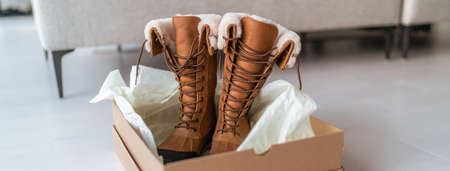 New winter boots buying new hiking shoes online shopping and delivery. Opening shoe box in living...