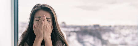 Sad upset young woman crying with mental health seasonal affective disorder at home breathing in...