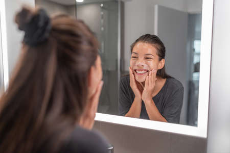 Face wash young Asian woman washing using facial scrub exfoliating skin cleansing of dead cells and oil for black pores clear skincare treatment.の写真素材