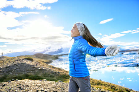 Iceland travel tourist enjoying nature landscape Jokulsarlon glacial lagoon on Iceland. Portrait of Woman standing outdoors by tourist destination landmark attraction. Vatnajokull National Park.の写真素材