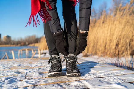 Ready for winter woman tying boot laces hiking boots for snow and ice anti slippery soles for...