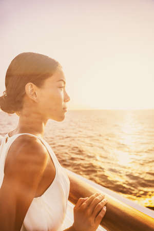 Cruise luxury travel elegant woman enjoying sunset view from balcony suite deck. Europe destination...