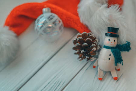 Christmas wooden snowman white wood background with miniature vintage toy, pine cone, glass ball...