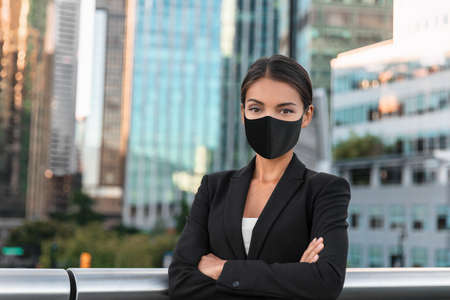 Asian business woman or real estate agent confident portrait wearing face mask for prevention in urban city backgroundの写真素材