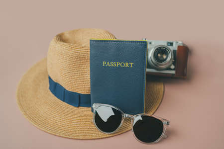Travel essentials : passport, sunglasses ,hipster hat ,vintage camera. Holiday objects on pink backgroundの写真素材