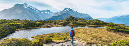 New Zealand Hiking. Young hiking man walking on trail at Routeburn Track during sunny day. Hiker tramping Key Summit Track in Fiordland National Park in New Zealand. Panoramic bannerの写真素材