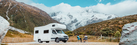 Motorhome camper van RV road trip on New Zealand. Couple on travel vacation adventure. Tourists looking at view of Aoraki Mount Cook National park and mountains next to rental car. Panoramic bannerの写真素材