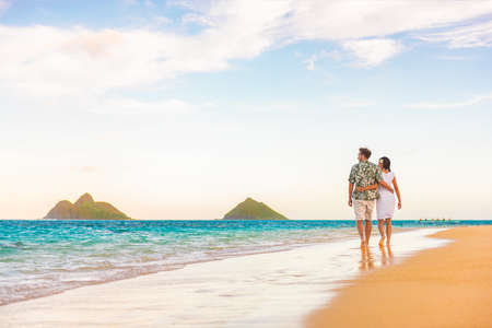 Hawaii beach vacation couple walking at sunset luxury travel holiday honeymoon destination. Newlyweds happy on Lanikai beach, Oahu, Hawaii.の写真素材