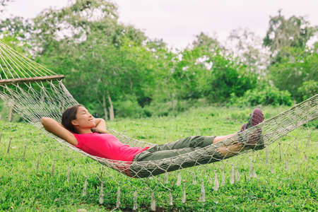 Happy summer relaxation woman sleeping in home backyard hammock relax enjoying retreatの写真素材