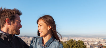 Young couple in love talking laughing together on outdoor city date. Dating in Barcelona, Spain. Interracial relationship of Asian woman and Caucasian manの写真素材