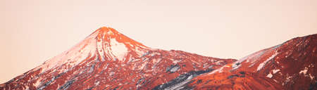 Volcano mountain peak landscape at sunset covered in snow winter background header. Panoramic of Teide Pico del Teide top, Tenerife, Canary Islands, Spain. Landscape nature outdoor backgroundの写真素材