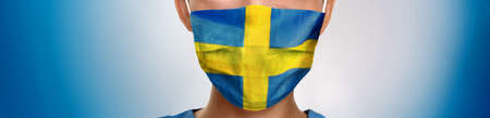 Sweden flag print on swedish doctor nurse man or woman face PPE on blue background panoramic banner.の写真素材