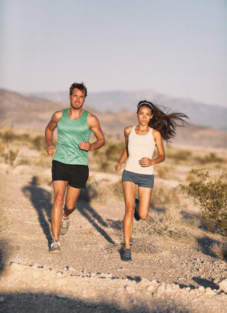 Runners couple running long distance ultra trail run race. Runner man and sport woman training...