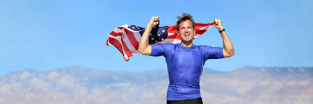 USA american athlete waving flag in success winning competition race on blue sky nature landscape background panoramic banner. Man sports win first place.の写真素材