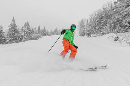 Skiing. Man on ski in Alpine ski concept - Skier skiing downhill doing hockey stop at mountain snow covered ski trail slopes in winter on perfect powder snow day while enjoying nature landscape
