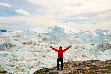 Climate Change and Global Warming Optimism and Positivity Concept. Man on Greenland arms raised in...