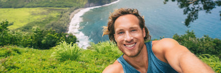 Travel selfie tourist man hiker taking phone photo on rainforest hike at Waipio Valley lookout in Big Island, Hawaii. Male backpacker smiling at camera on adventure nature travel banner panoramicの写真素材