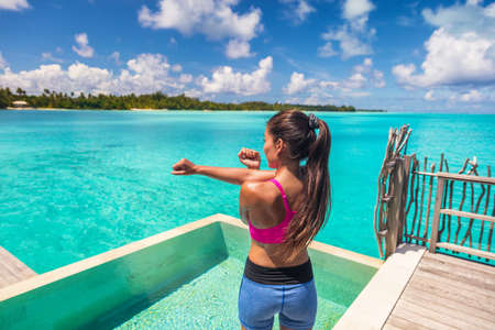 Fit young woman stretching arms warm up exercise before workout at luxury resort hotel bungalow...