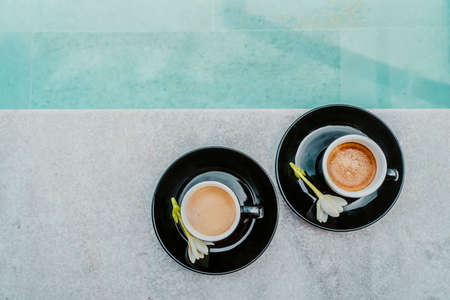 Coffee in espresso cups for two people on luxury pool side on vacation. High end resort hotel. Top view of mugsの写真素材