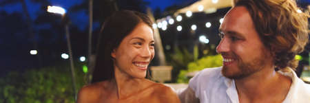 Dating couple in love on online first date at bar on night out banner panoramic. Asian woman, Caucasian man having fun laughing smiling, biracial relationship young peopleの写真素材